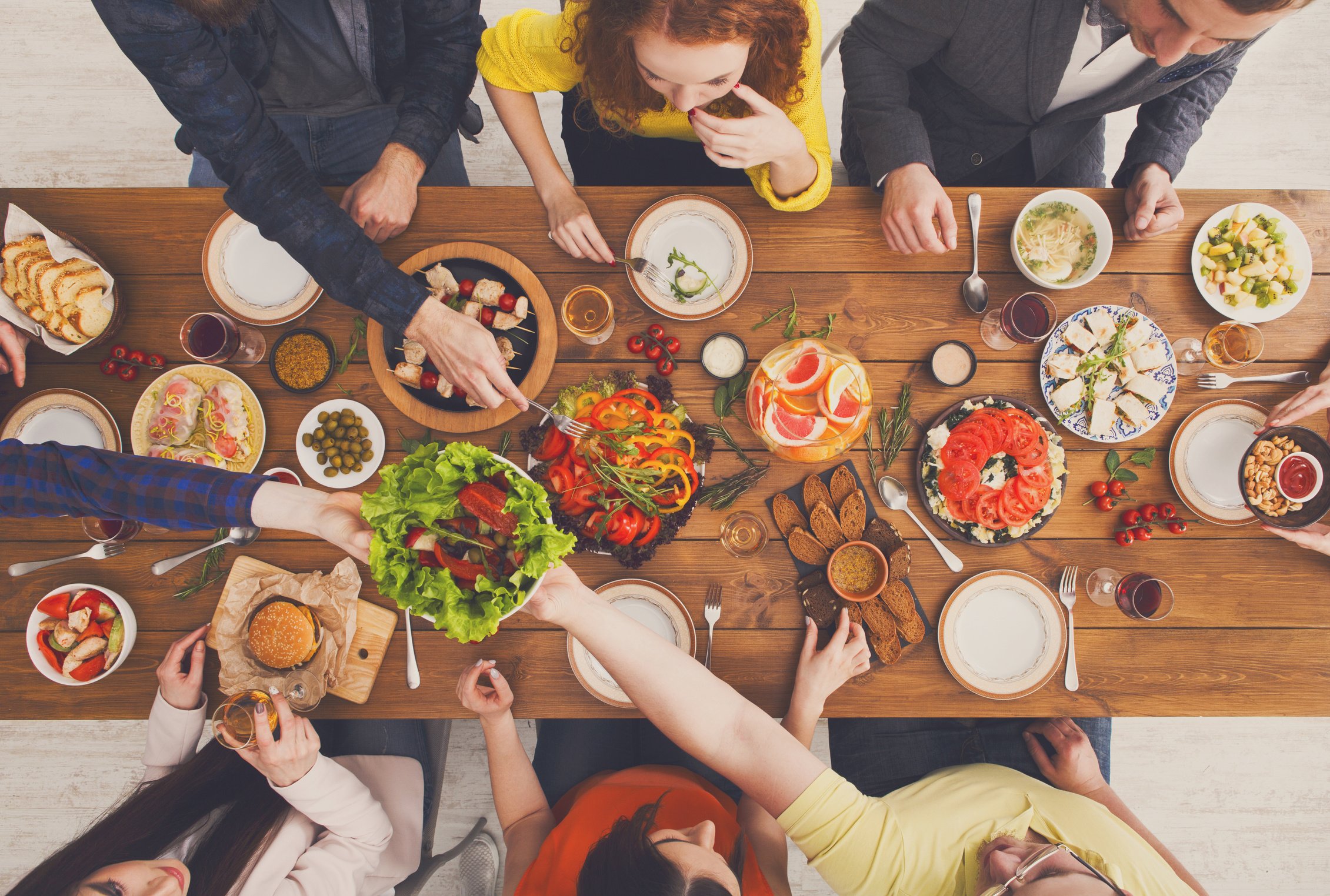 People eat and share healthy meals at served table dinner party